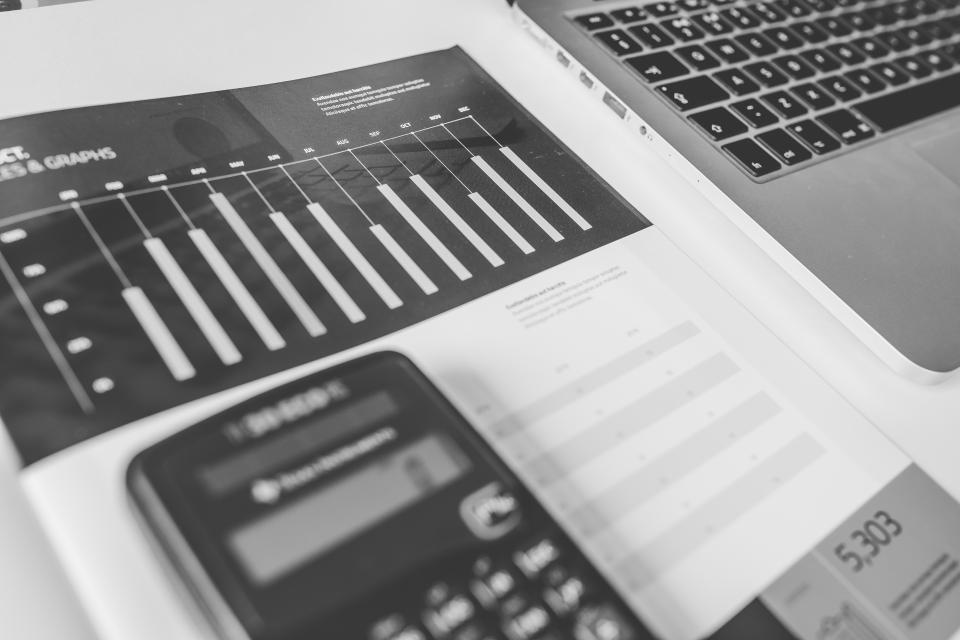 A desk calculator beside printed figures